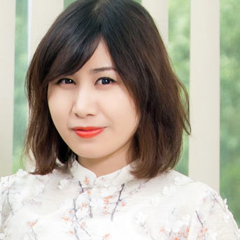 Female student from Vietnam smiling at the camera wearing white