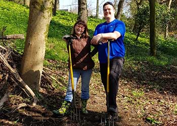 Two volunteers digging with forks