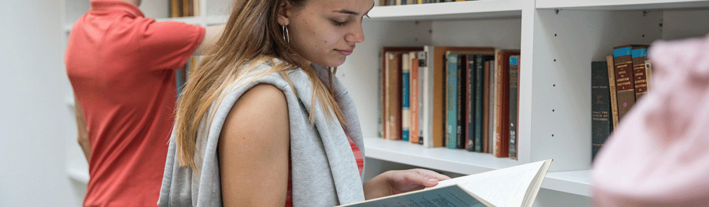 Student in library reading book 