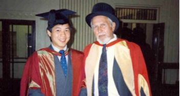 student smiling standing next to lecturer