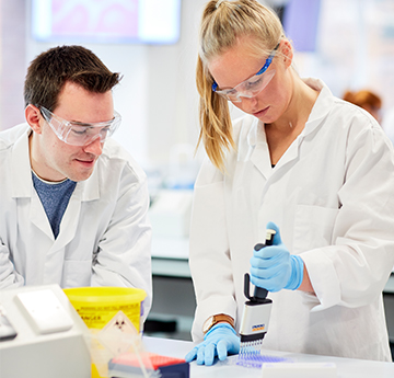 Students working in lab together with pippet.