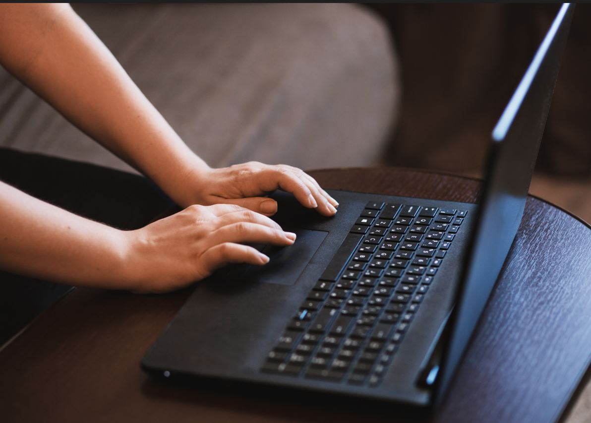 latop on table with hands typing