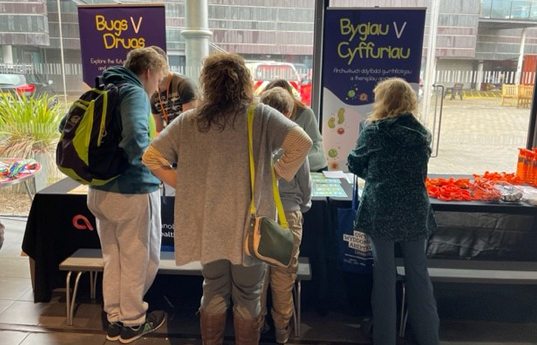 group of mixed age and mixed gender people engaged with the interactive workshop at science festival