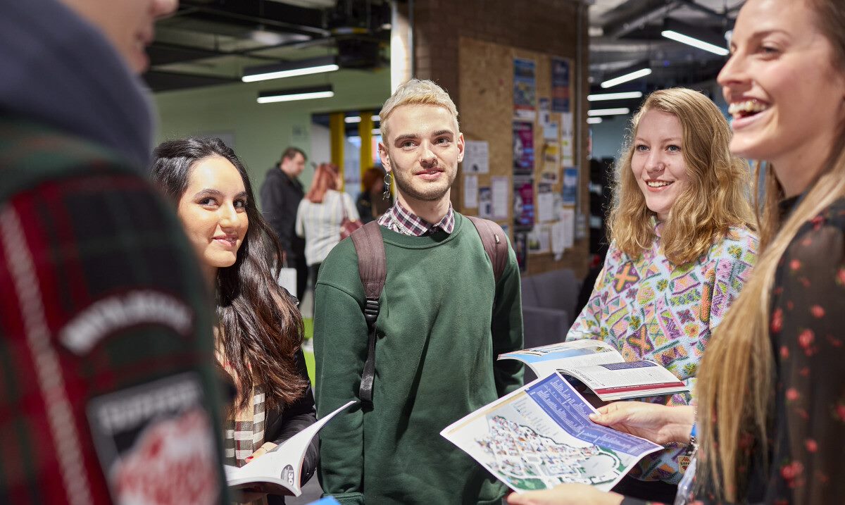 A group of people talking in an open day event.