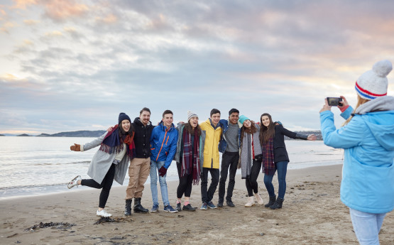 Students lounging on the beach at sunset