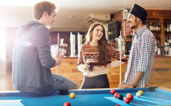 Students playing pool in JC's bar