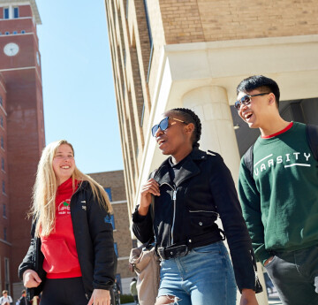 3 Students walking on bay campus