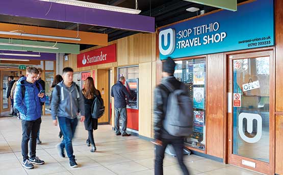 Students by the bank and travel shop