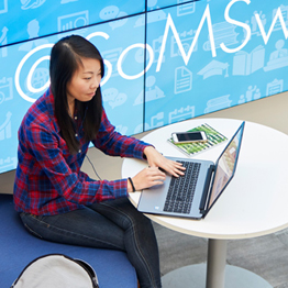 Female students sat on a laptop at a desk