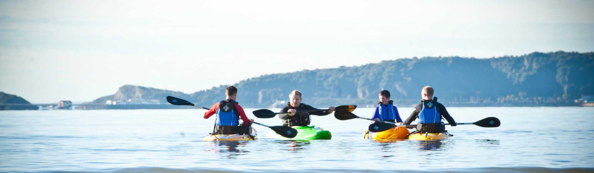 4 students on kayaks in the sea