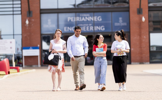 Male and female students walking in a line in from of Engineering building on Bay Campus.