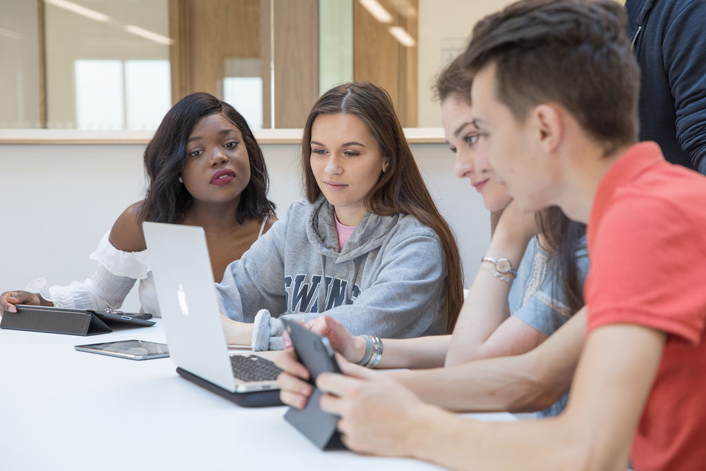 Students sat in front of a lap top