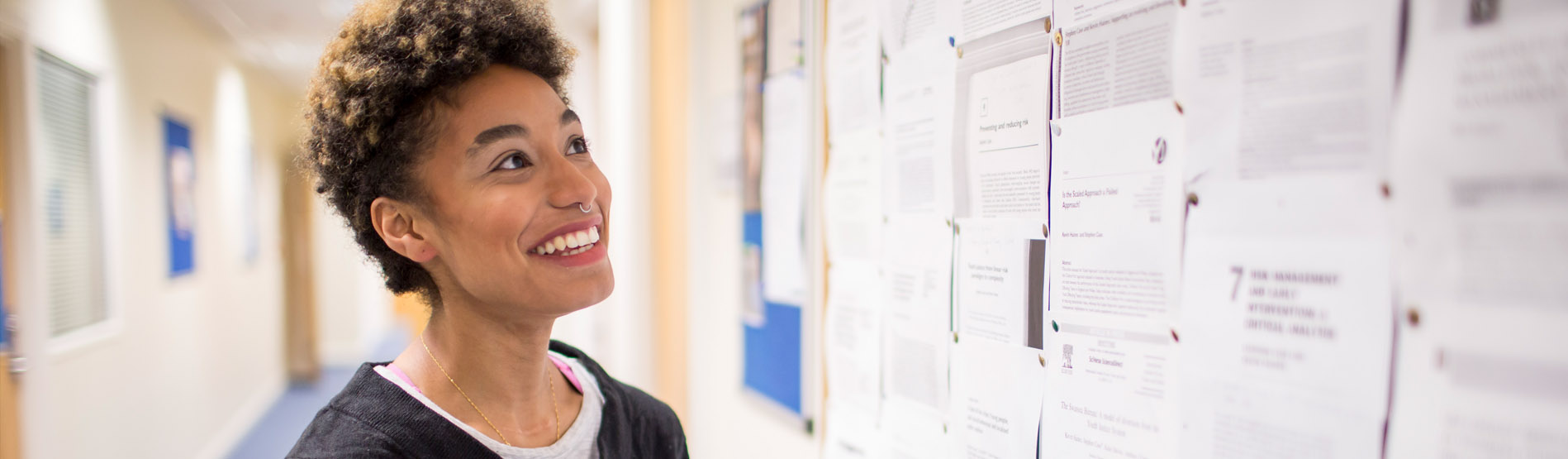 a student looking at a notice board