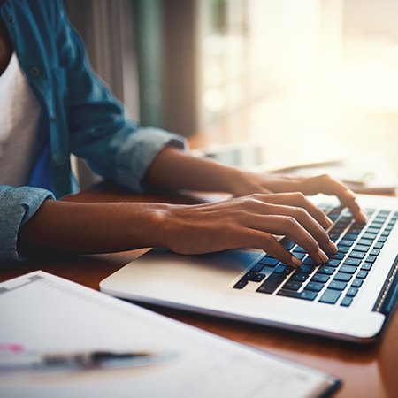 A woman typing on a laptop 