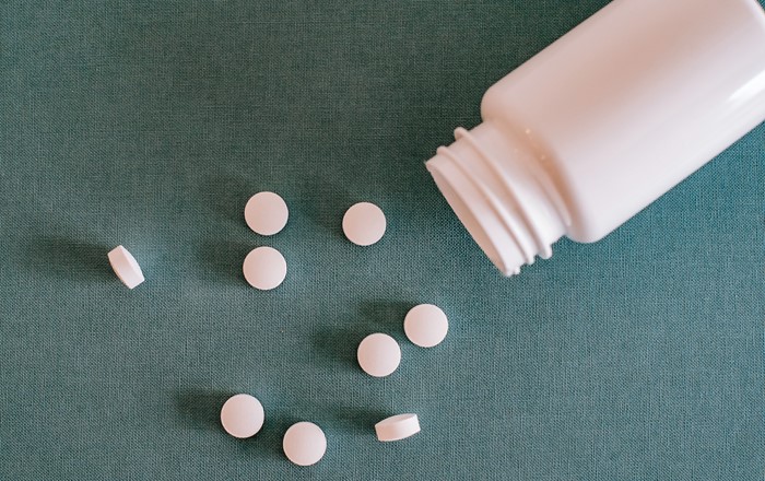 Image show pill bottle and pills.