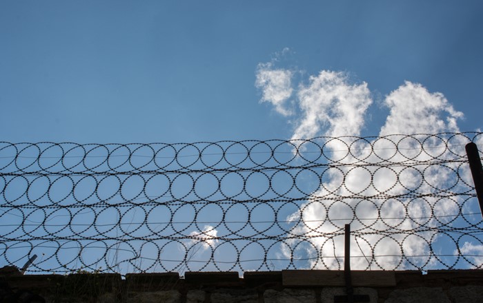 Barbed wire on prison wall: the impact of Covid restrictions on prisoners and prisons is to be examined in a new Swansea-led research project