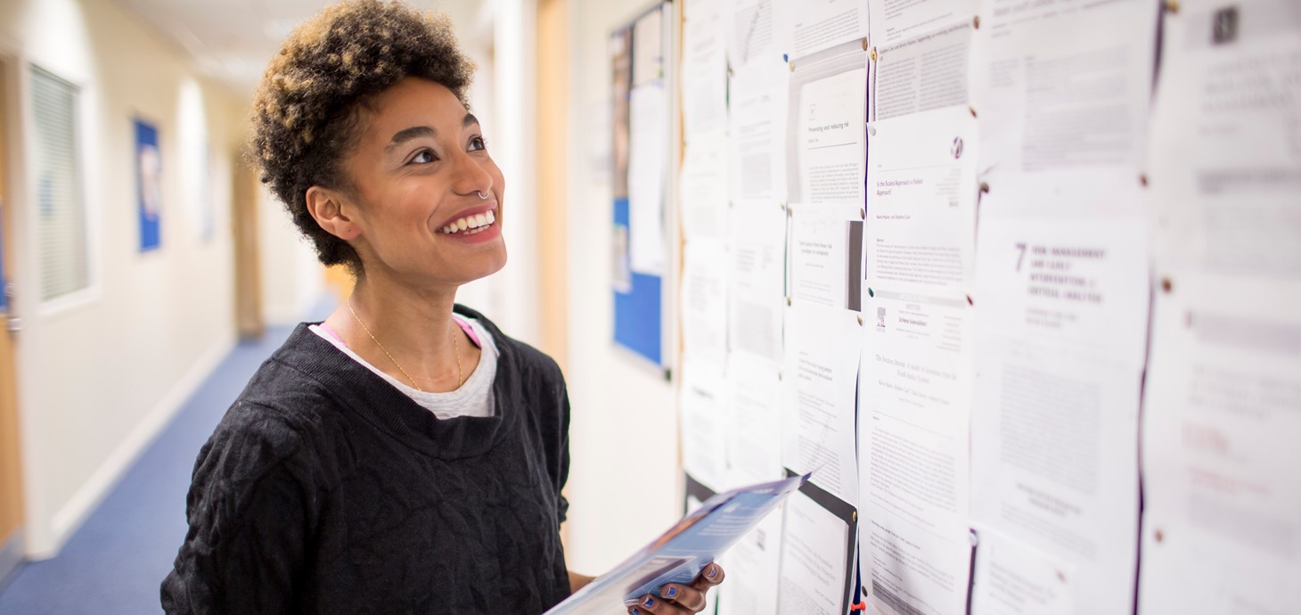 A student looking at a bulletin board.