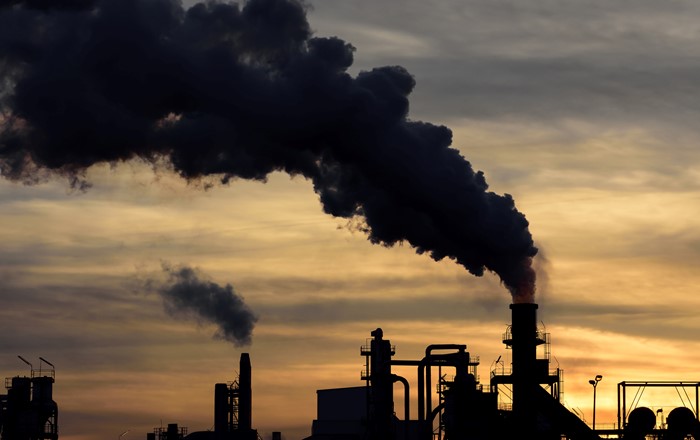 Industrial site with smoke billowing into atmosphere.