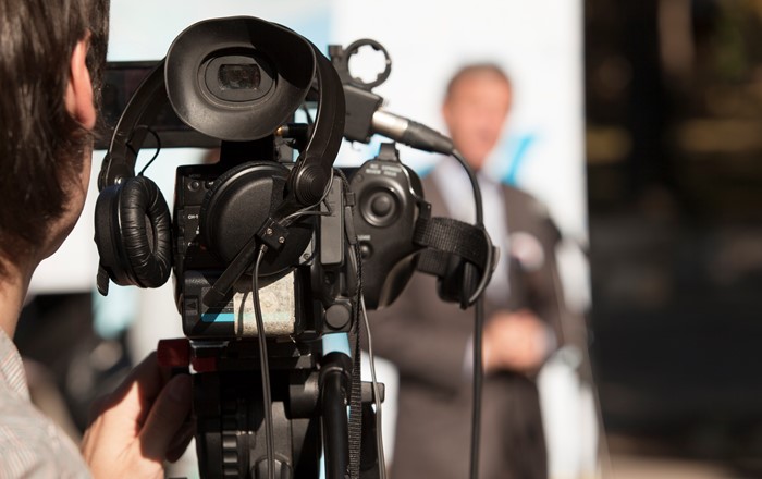 A video camera in use during a television broadcast.