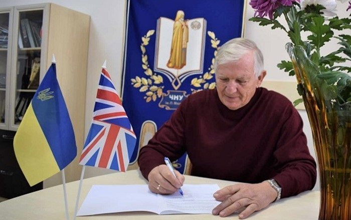 Professor Paul Boyle in Swansea (left) and Professor Leonid Klymenko (right) in Mykolaiv, sign the agreement between their two universities. It outlines the framework for collaboration, including research and academic partnerships.