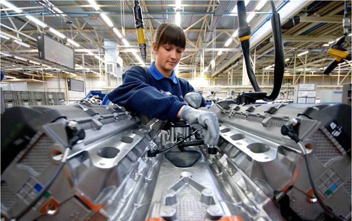 Female engineer adjusting machinery in a factory.