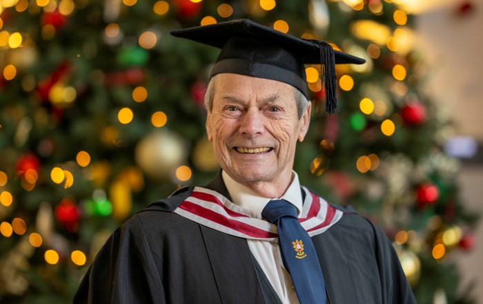 A photo of John in his cap and gown at graduation.