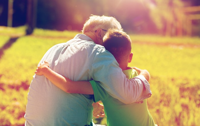 An older person and child hug.