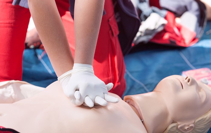 A person performing CPR on a manikin