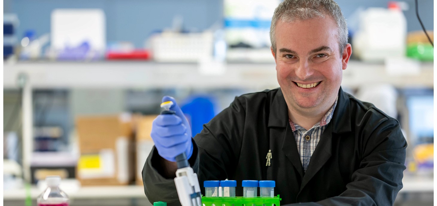 Male scientist in laboratory with test tubes