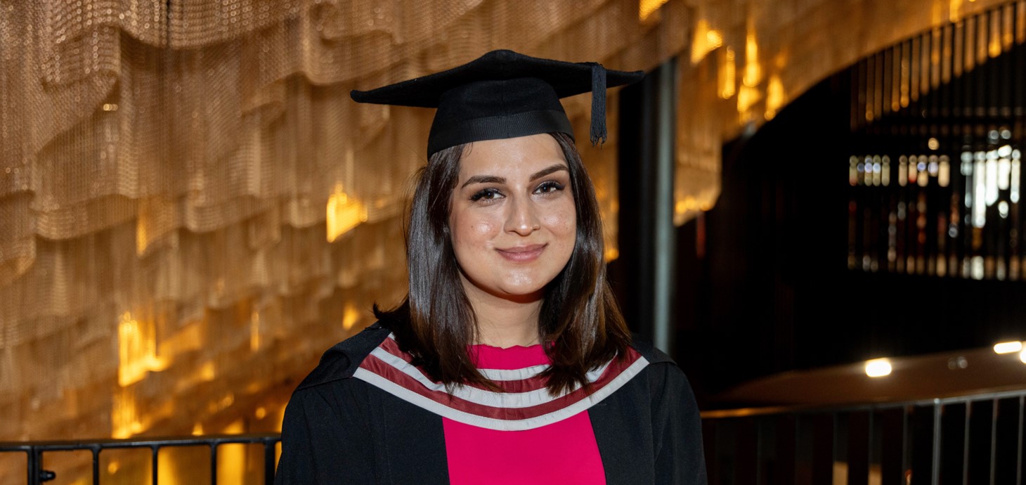 Elham in her cap and gown at graduation.