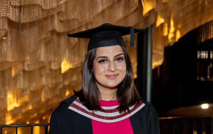 Elham in her cap and gown at graduation.