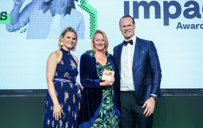 Emma Frearson Emmanuel, Associate Director of Marketing, Recruitment and International at Swansea University, on stage holding the award, standing next to (left) Julia Lambo, Director of Corporate Communications and ESG at Navitas, and (right) Scott Jones, Group CEO at Navitas. 