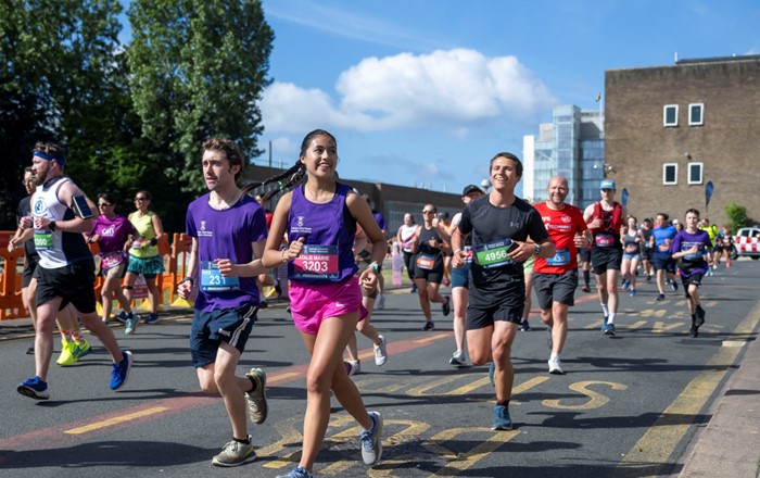 Group of runners taking part in a run in front of buildings