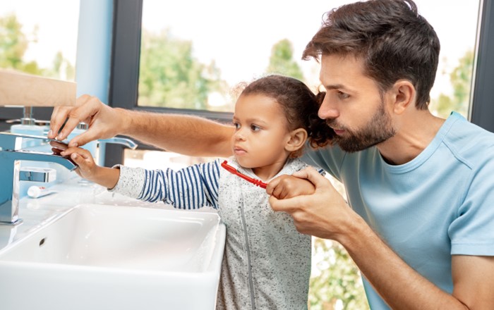 A photo of a family brushing their teeth.