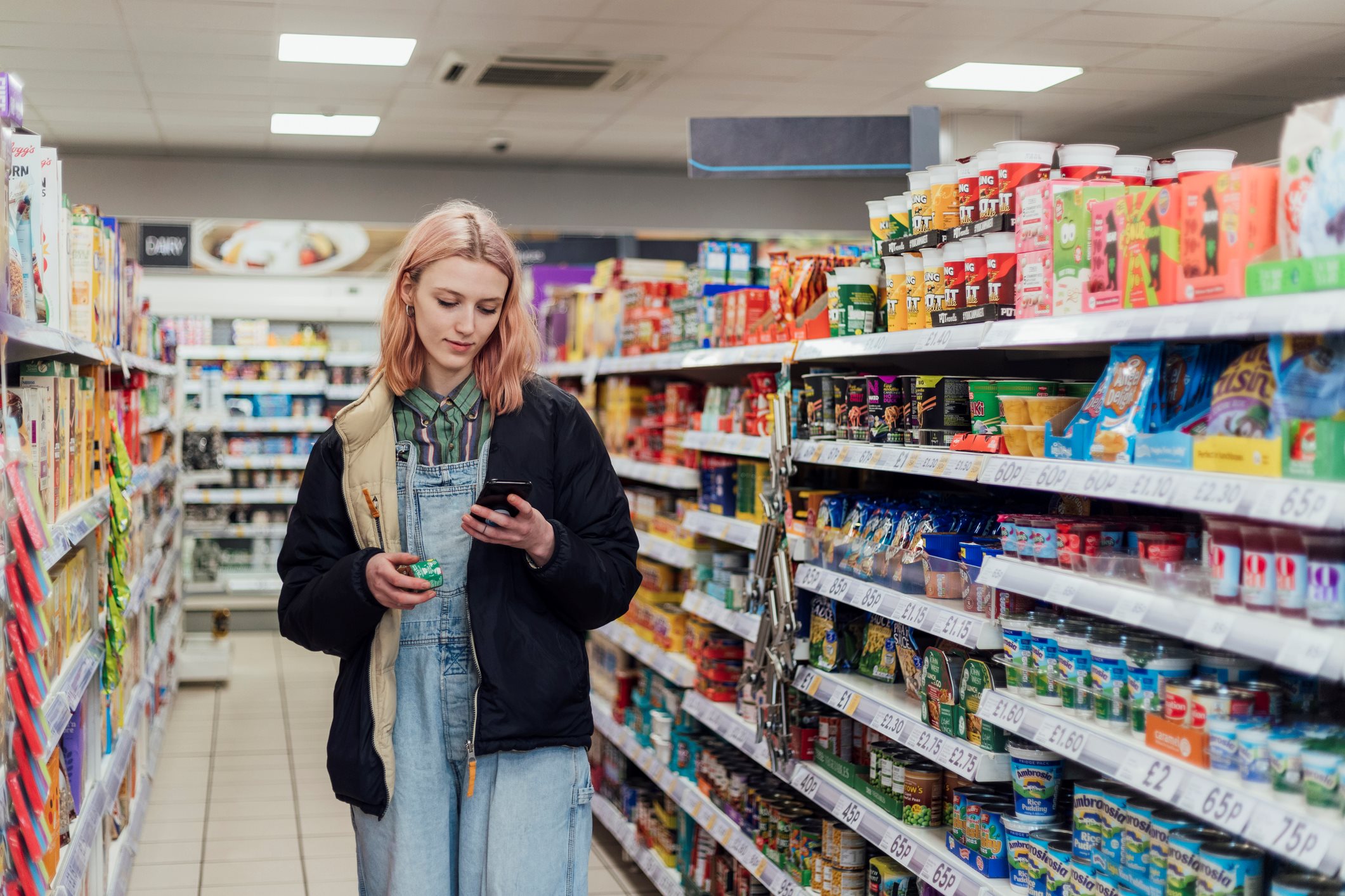 A young lady in the supermarket checking her phone