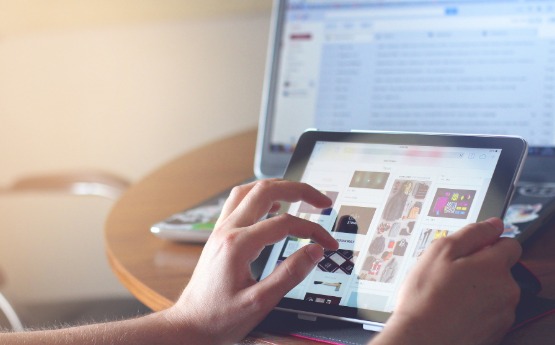 person using a tablet in front of a computer