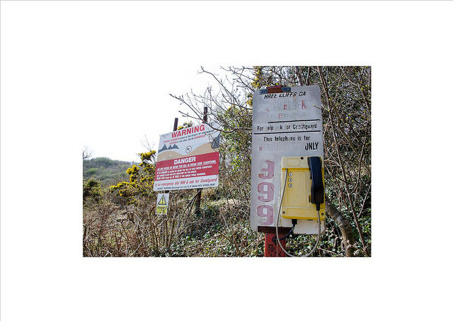 An emergency phone with a danger sign in the background