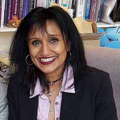 Professor Yamni Nigam in front of books