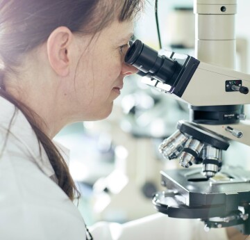 image of medical student using a microscope