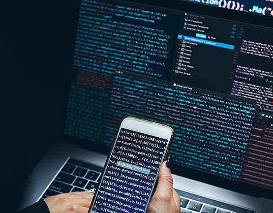 computer coding running on laptop and phone screens