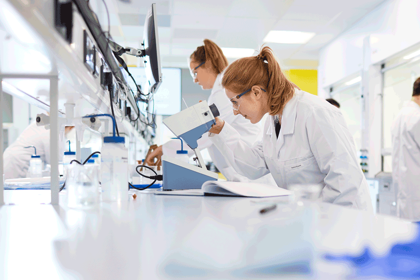 Chemistry student looking through a microscope 