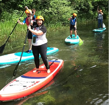 People paddleboarding on river