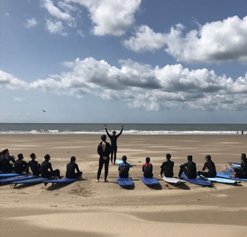 People taking a surf lesson on the beach