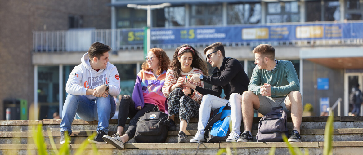 Students sitting outside Fulton House in the sun 