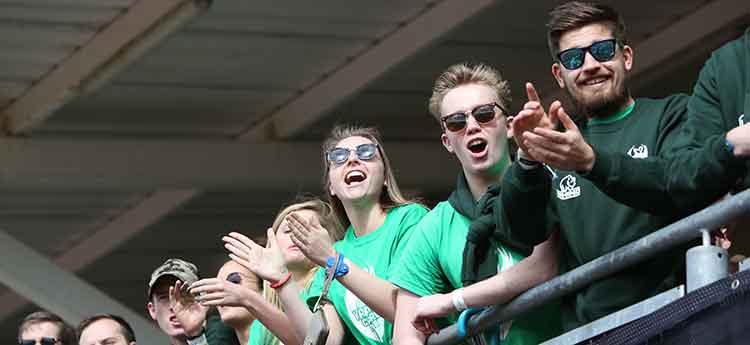 Sport Swansea supporters dressed in green, clapping and cheering