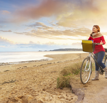 Student cycling along Swansea Bay