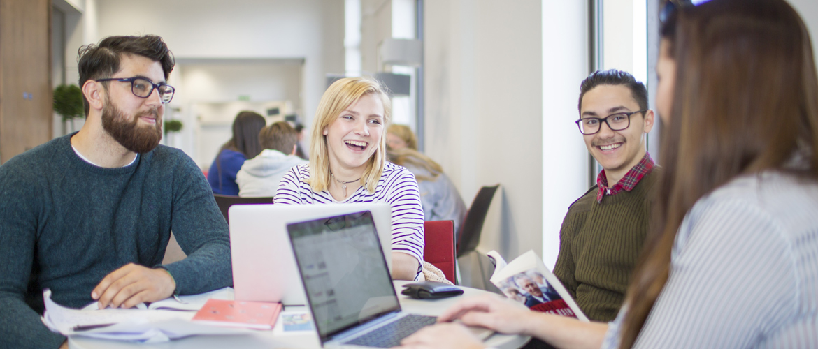 Four students studying and laughing