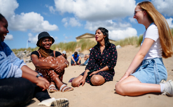 A group of students sitting on the beach