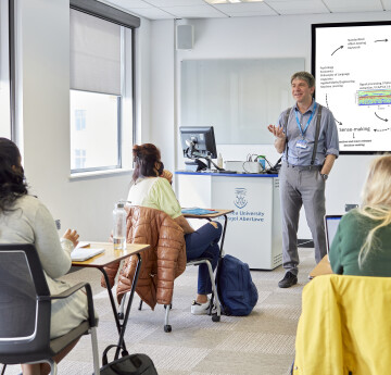 A lecturer standing at the front of the room giving a lecture