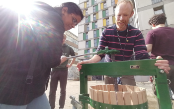 Ben, Our Biodiversity Officer and a student using an apple pressing machine